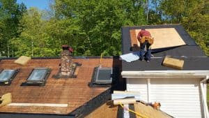 man standing on roof to replaceing
